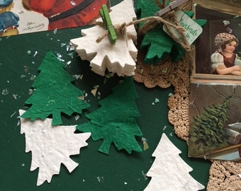 May include: A stack of white paper Christmas tree ornaments with a tag that says "Handmade with Love" and a stack of green paper Christmas tree ornaments.
