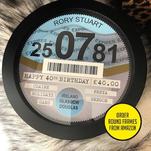 May include: A black and white round framed sign with a blue background. The sign says "RORY STUART" and "HAPPY 40TH BIRTHDAY &pound;40.00". The sign also has a barcode and a number "250781".