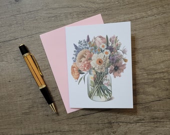 Könnte beinhalten: Eine weiße Karte mit einer Aquarell-Illustration eines Blumenstraußes in einem Glasgefäß. Die Blumen sind rosa, weiß, lila und blau. Die Karte liegt auf einem rosa Umschlag.