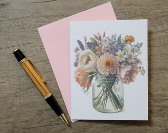 Könnte beinhalten: Ein Strauß aus rosa, weißen und pfirsichfarbenen Blumen in einem durchsichtigen Glas. Die Blumen sind in einer Vase auf weißem Hintergrund angeordnet.