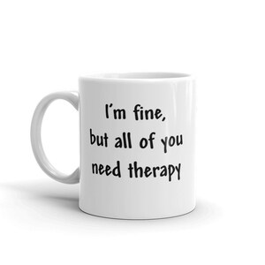 May include: White ceramic coffee mug with black text that reads "I'm fine, but all of you need therapy."