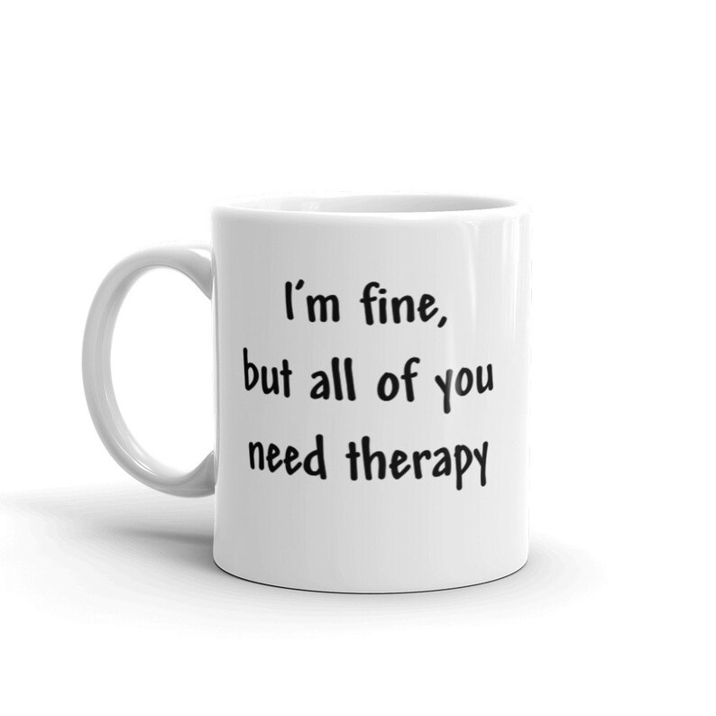 May include: White ceramic coffee mug with black text that reads "I'm fine, but all of you need therapy."