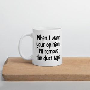 May include: White ceramic mug with a black text saying "When I want your opinion, I'll remove the duct tape."