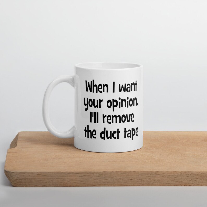 May include: White ceramic mug with a black text saying "When I want your opinion, I'll remove the duct tape."