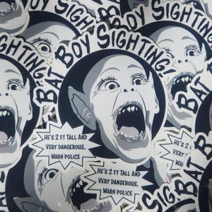 May include: A set of black and white stickers featuring a cartoon image of a screaming bat boy with the text "Bat Boy Sighting!" and "He's 2 ft tall and very dangerous, warn police".
