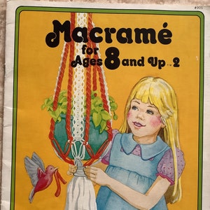 May include: An illustration of a macramé project for ages 8 and up. The image features a young girl holding a macramé plant hanger with a green plant inside. The text "Macramé for Ages 8 and Up 2" is displayed at the top.