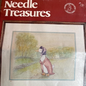 May include: A ColorArt Crewel Needle Treasures kit featuring a framed cross-stitch of Mima Puddle-Duck from Beatrix Potter. The artwork depicts the duck in a bonnet and shawl, standing in a field. The kit size is 16" x 13" without the mat.