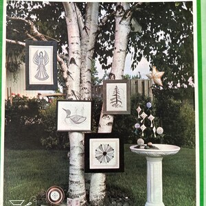 May include: A softcover book titled BLACKWORK from Threads and Things by Karen R. Buell. The cover features a photograph of framed blackwork embroidery pieces hanging on a birch tree, including an angel, a duck, a tree, and a geometric design.