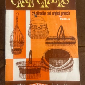 Peut inclure: Un livret d'instructions vintage intitulé Cane Capers présentant 22 projets originaux. La couverture affiche des illustrations de divers paniers tressés et d'une suspension en brun et orange, avec le texte 50c et another ARBEE instruction.