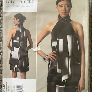 May include: A Guy Laroche Vogue Patterns Paris Original dress pattern, V1240, featuring a black and white geometric print halter dress. The pattern includes sizes DD (12-14-16-18). The image shows a woman modeling the dress.