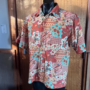 Peut inclure: Une tasse en céramique blanche avec une anse noire et le texte "But First, Coffee" en noir, dans une police manuscrite. La tasse est posée sur une surface blanche.