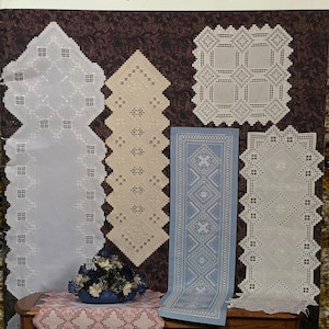Könnte beinhalten: Ein Softcover-Buch mit dem Titel Award-Winning Designs in Hardanger Embroidery 1993, zusammengestellt von Susan L. Meier und Rosalyn K. Watnemo. Das Cover zeigt Fotografien verschiedener weißer und blauer Hardanger-Stickereiläufer und Deckchen.