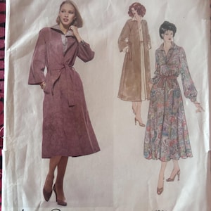 May include: Vintage Vogue American Designer sewing pattern featuring three dress designs. The pattern includes a long coat dress with a belt, a long coat, and a floral print dress. The designer's name, Jerry Silverman, is printed at the bottom.