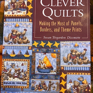 Puede incluir: Un libro de tapa blanda titulado Clever Quilts: Making the Most of Panels, Borders, and Theme Prints por Susan Teegarden Dissmore. La portada presenta un collage de osos de peluche en entornos náuticos con veleros y faros.