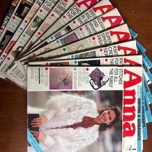 May include: A collection of vintage "Anna" knitting and needlecraft magazines. The magazines feature a woman wearing a white, textured jacket on the cover. The covers display the title "Anna" in large red letters, with various craft-related headlines.
