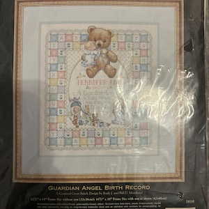 Puede incluir: Kit de punto de cruz contado enmarcado titulado "Guardian Angel Birth Record". El diseño presenta un oso de peluche, un bebé y el texto "Jennifer Ann". El kit incluye hilo de bordar de algodón, cuentas y un alfabeto para personalizar. Tamaño del marco sin paspartú: 32x36cm.