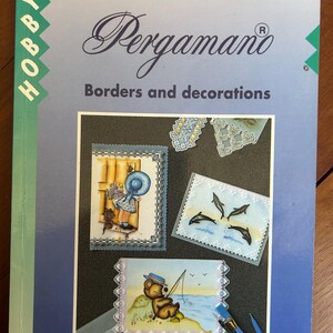 May include: A softcover instructional book titled Martha Ospina Pergamano Borders and decorations. The light blue cover features a vertical green stripe with the word Hobby and displays several examples of parchment craft cards with intricate designs.