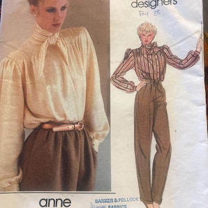 May include: A vintage Vogue sewing pattern for an Anne Klein design, featuring a blouse and trousers. The illustration shows a cream blouse and brown trousers. The pattern is labelled "Fay 88". The pattern is for fabrics and cannot be exchanged.