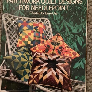 May include: A book titled "Patchwork Quilt Designs for Needlepoint" by Frank Fontana. The cover features colorful needlepoint pillows with geometric and star patterns. The book is part of the Dover Needlework Series.