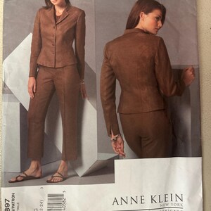 May include: A sewing pattern envelope for an Anne Klein Vogue American Designer suit, model V2897, size G (20-22-24). The front shows a brown blazer and matching trousers from front and back views, featuring a notched collar and button closure.
