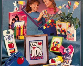 May include: A collection of plastic canvas craft projects, including a cat picture, a dinosaur, a teddy bear, and a unicorn. The projects are colorful and feature various designs. The image also shows a book titled "Plastic Canvas" and the text "STUDY TIME!"