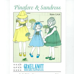 May include: A vintage sewing pattern titled "Pinafore & Sundress" featuring illustrations of children's dresses with sunhats. The pattern includes sizes 2, 4, and 6. The Grace L. Knott Smocking Supplies Ltd. pattern is printed in Canada.