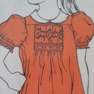 May include: A vintage sewing pattern for a girl's dress with puffed sleeves and a Peter Pan collar. The dress has a gathered bodice and a simple skirt. The pattern includes instructions for making the dress and a diagram of the pieces.
