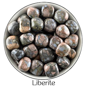 Könnte beinhalten: Eine Schale gefüllt mit getrommelten Liberit-Steinen. Die Steine sind eine Mischung aus Grau, Schwarz, Rosa und Blau mit einem gesprenkelten Muster.