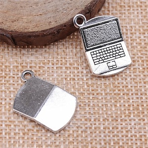May include: Two silver charm pendants, one shaped like a laptop with a keyboard and the other shaped like a rectangle.