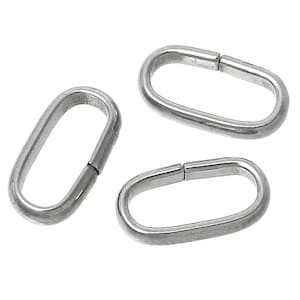 May include: Three silver oval jump rings, each with a slightly different angle, are shown against a white background.