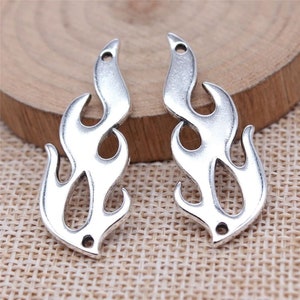 May include: Two silver-toned metal flame charms with two holes each. The charms are in the shape of a stylized flame.