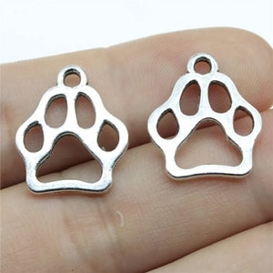 May include: Two silver metal paw print charms with a loop at the top for attaching to jewelry or other crafts.