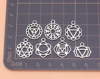 May include: Seven silver metal charms in the shape of the seven chakras. Each charm is about 1.5 cm in diameter and features a unique geometric design.