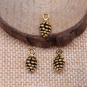 May include: Three gold-toned metal pine cone charms with a loop at the top for attaching to jewelry or crafts.