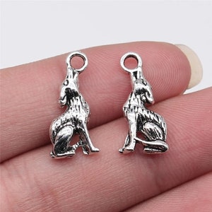 May include: Two silver-toned wolf charms with a loop at the top for attaching to jewelry or other crafts.