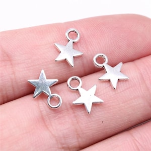 May include: Four silver star-shaped charms with a jump ring for attaching to jewelry or crafts.