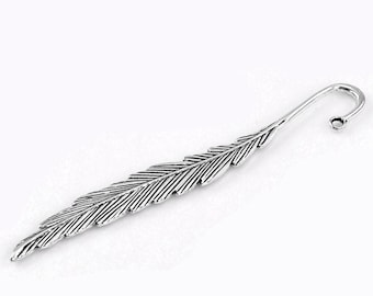 May include: Silver feather bookmark with a curled end. The bookmark is detailed with lines to resemble a feather.