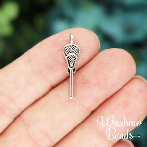 May include: Silver lacrosse stick charm pendant. The charm is detailed with a mesh net and a stick.
