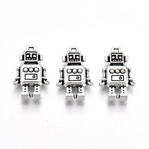 May include: Three silver robot charms with black details. Each charm features a robot with a round head, two arms, two legs, and a rectangular body.
