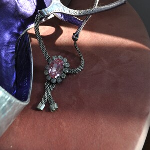Peut inclure: Une chaussure argent&eacute;e avec une doublure violette et un bracelet de cheville en strass rose. Le bracelet est de conception en cha&icirc;ne et comporte un grand strass rose au centre.