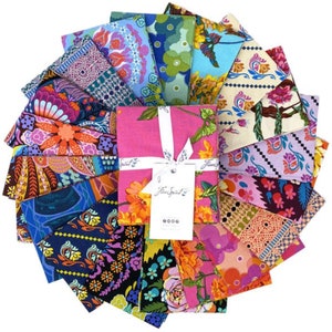 May include: A collection of colorful fabric squares arranged in a circular pattern. The fabrics feature floral and abstract designs in shades of pink, blue, orange, and purple. A pink fabric bundle is tied with a white ribbon and a tag that reads "Free Spirit".