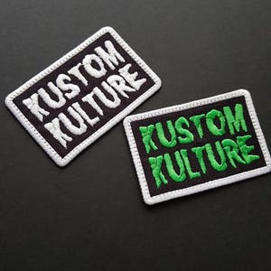 Pode incluir: Dois remendos de tecido preto com costuras brancas. Um remendo tem o texto "KUSTOM KULTURE" em letras brancas. O outro remendo tem o mesmo texto em letras verdes.