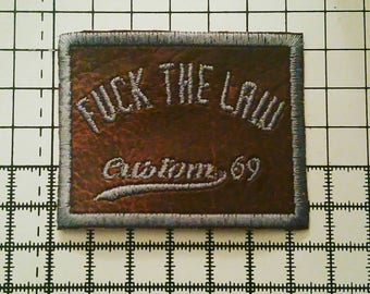 Fuck the law patch. This embroidered patch is Leatherette with a medium grey stitch. This is a sew on patch for bad asses.