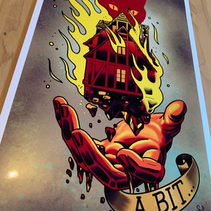 May include: A hand holding a burning house with a red cat on top. The flames are yellow and orange. The house is red and has a white window. The hand is red and has dripping flames. A banner below the hand says "I broke a bit..."