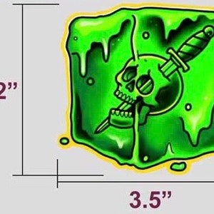 Könnte beinhalten: Grüner Schleim-Aufkleber mit einem Schädel und einem Dolch darin. Der Aufkleber ist 3,5 Zoll breit und 3,12 Zoll hoch.