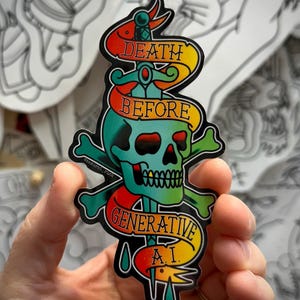 Puede incluir: Una pegatina que muestra una calavera de color verde azulado atravesada por una espada, envuelta en una cinta amarilla y roja con el texto DEATH BEFORE GENERATIVE A.I. El diseño incluye huesos cruzados verdes detrás de la calavera.