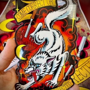 May include: A white wolf with a red tongue and blue eyes is jumping in the air. The wolf is surrounded by flames and clouds. The text "Come Correct Or Get Corrected" is written on a yellow banner above the wolf.