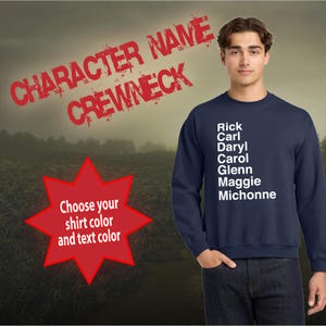May include: A navy blue crewneck sweatshirt with white text that reads "CHARACTER NAME CREWNECK" in a distressed font. The text on the sweatshirt lists the names "Rick, Carl, Daryl, Carol, Glenn, Maggie, Michonne". A red star with the text "Choose your shirt color and text color" is in the lower left corner of the image.