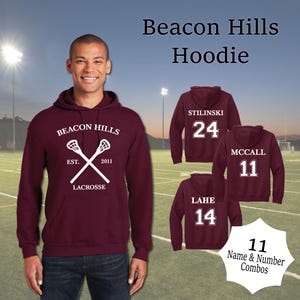 May include: Burgundy hooded sweatshirt with white lacrosse sticks and the text "Beacon Hills Est. 2011 Lacrosse". Three additional sweatshirts are shown with white text on the back: "Stilinski 24", "McCall 11", and "Lahe 14".