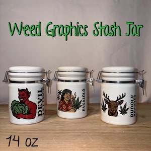 May include: White ceramic stash jars with metal clasps. Each jar features a different graphic: a red devil with lettuce, a person with a cannabis leaf, and a deer with cannabis leaves. The text "Weed Graphics Stash Jar" is above the jars. Each jar holds 14 oz.